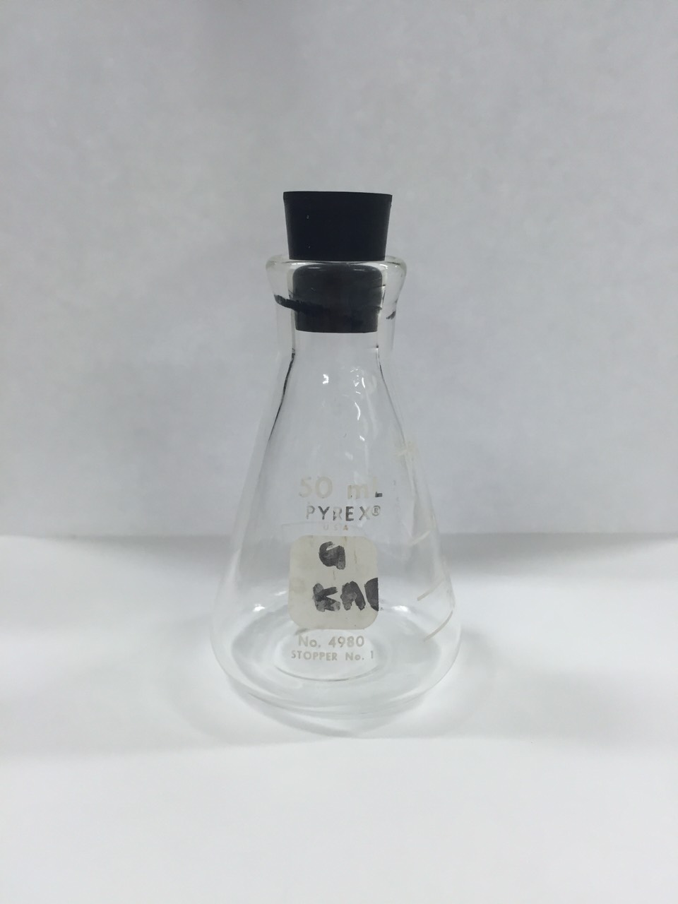 Figure 17 — Reference photograph of a #5-class rubber laboratory stopper (here seated in an Erlenmeyer flask — the same general type used historically). The originals were salvaged from the Los Alamos chemistr…